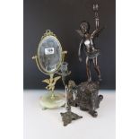 Two bronzed cast metal candlesticks in the form of cherubs together with a mirror.