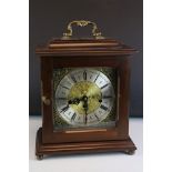 A mahogany cased two train movement bracket clock with brass face and carrying handle.