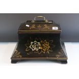 A sarcophagus shaped black wooden box with hand painted decoration and velvet lined interior.