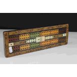 A vintage decorative cribbage board with masonic marks to centre.