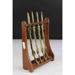 Four Trench Art Brass Desk Paperknives in the form of Rifles contained within a wooden gun rack,