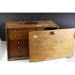 A vintage wooden portable collectors cabinet with 5 internal drawers of various sizes.