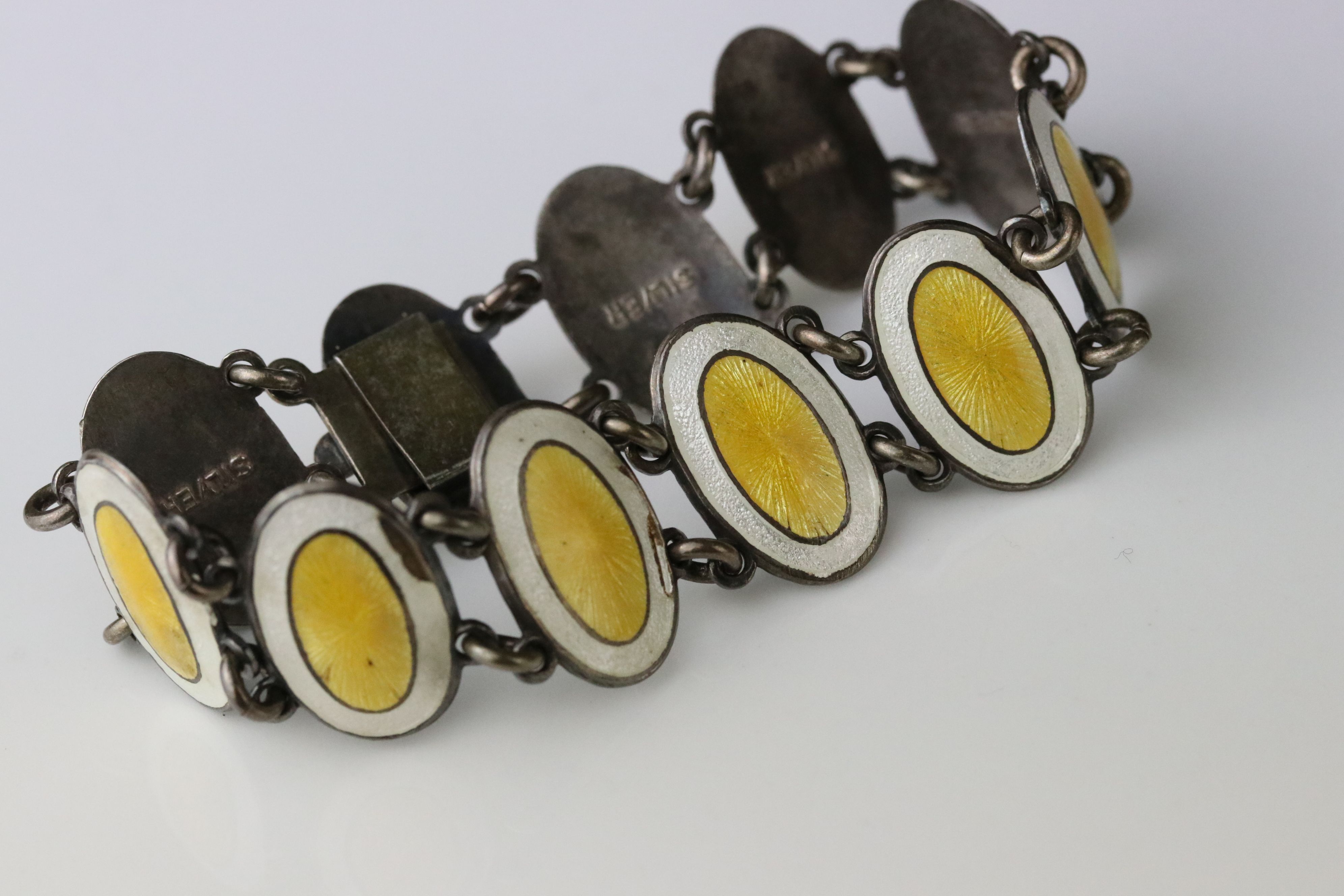 Early 20th century enamelled silver panel bracelet, eleven oval yellow and white enamelled panels, - Image 2 of 6