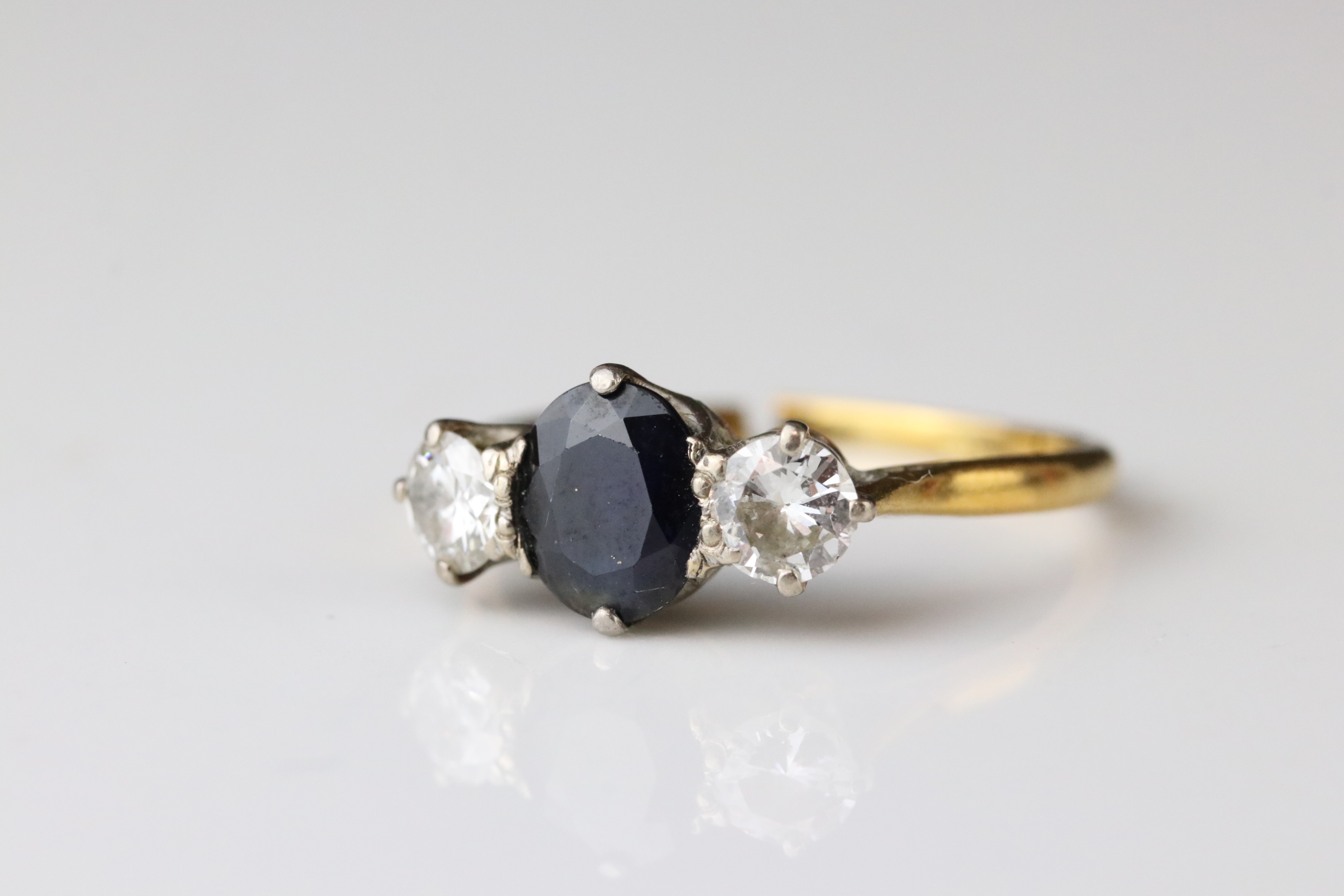 Sapphire and diamond three stone 18ct yellow gold platinum set ring, the oval mixed cut blue-black