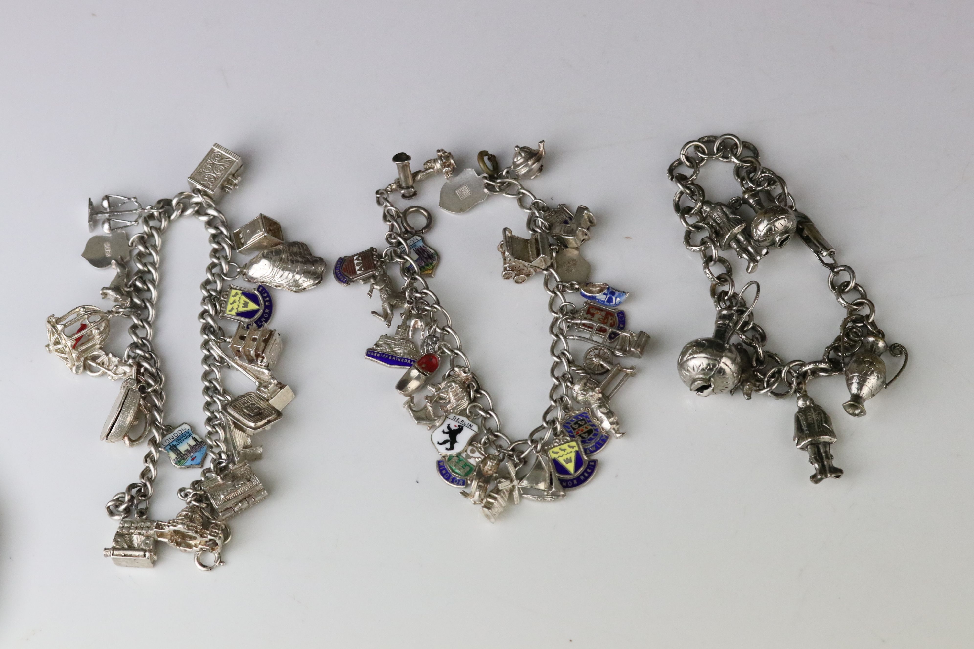 Silver curb link charm bracelet with eighteen silver and white metal charms, length approx 23cm (