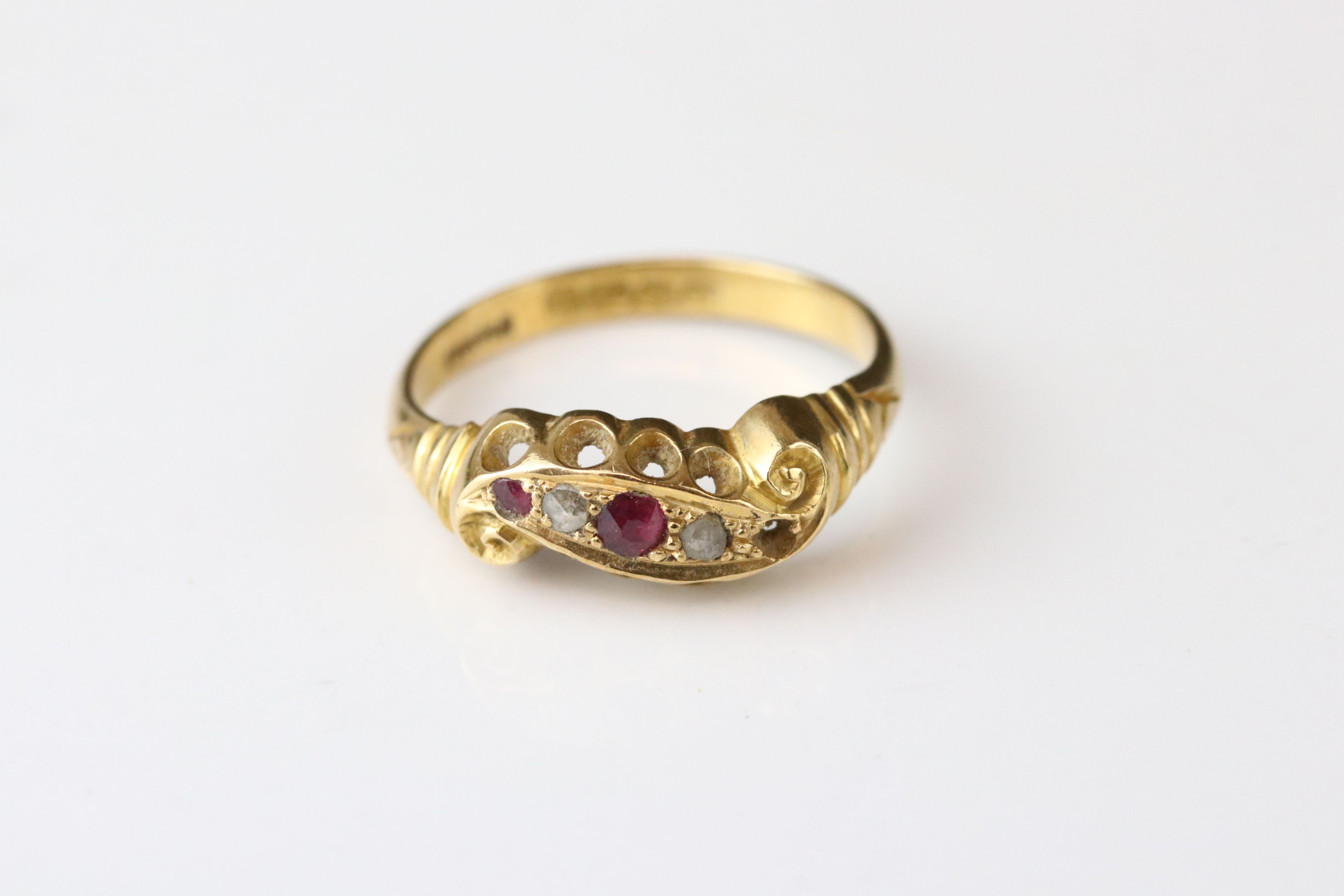 Early 20th century ruby and diamond 18ct yellow gold scroll head ring, two small round mixed cut