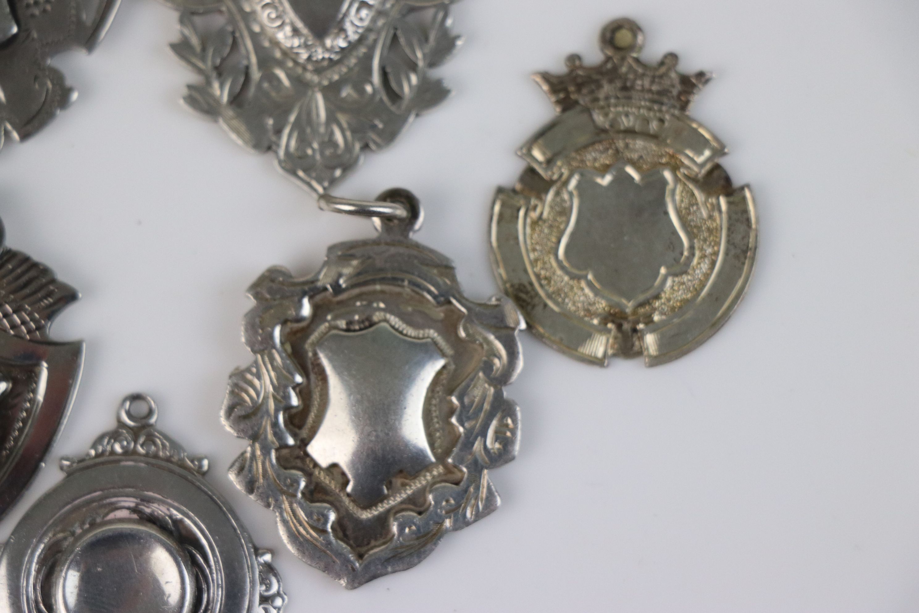 A collection of seven fully hallmarked sterling silver watch fob medallions. - Image 5 of 6