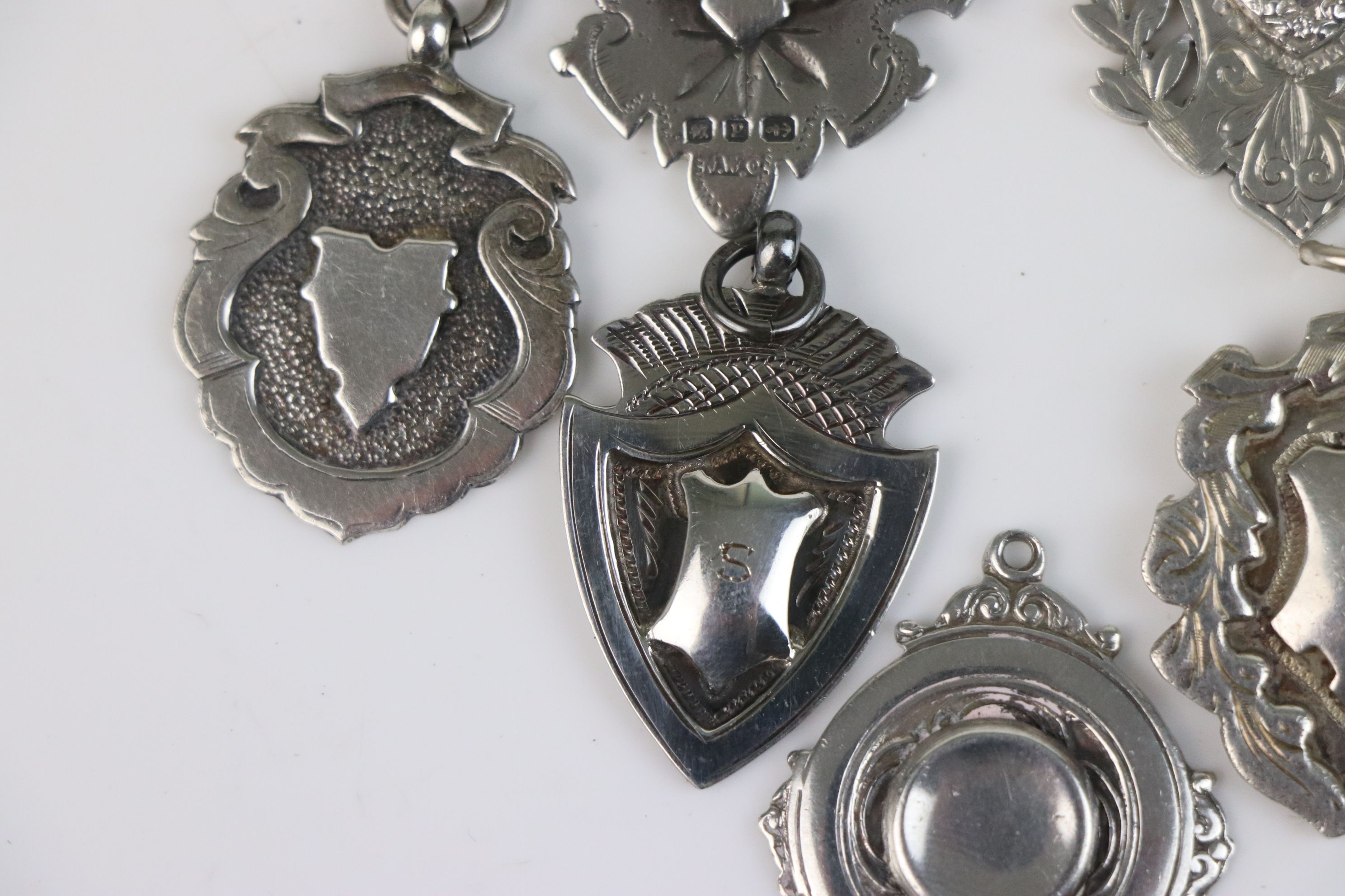 A collection of seven fully hallmarked sterling silver watch fob medallions. - Image 3 of 6