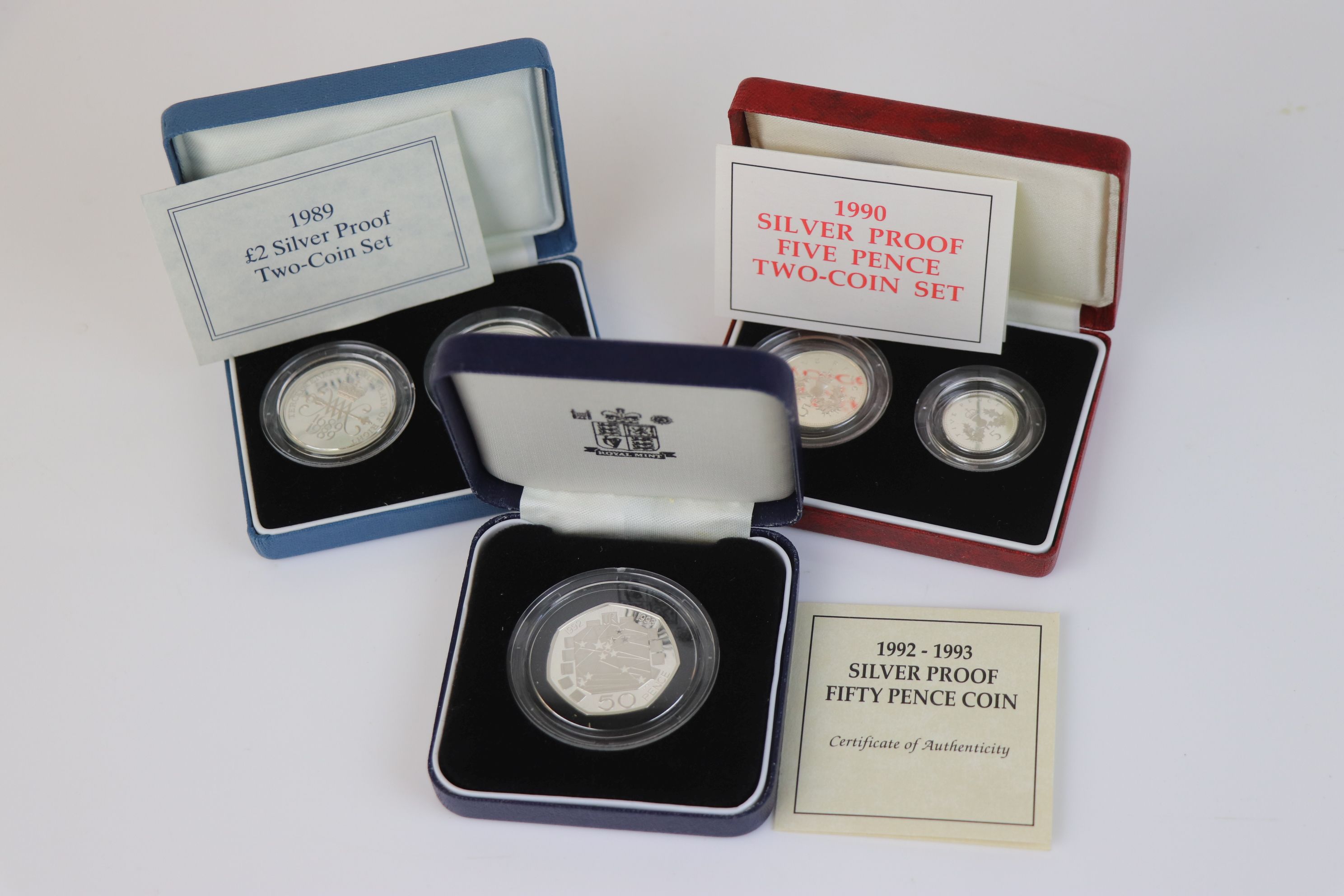 Three cased Royal Mint silver proof coin sets to include the 1992-1993 silver proof fifty pence