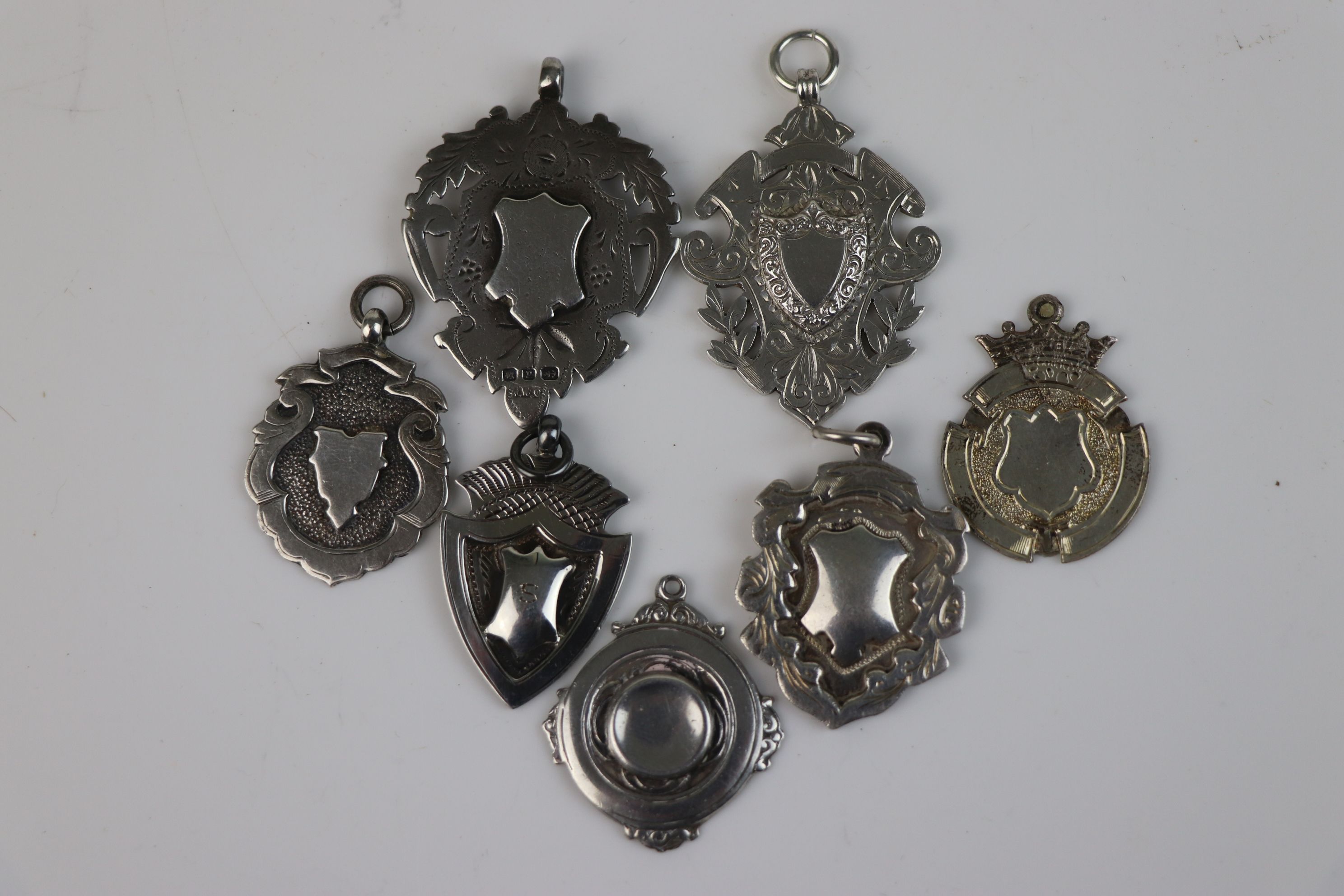 A collection of seven fully hallmarked sterling silver watch fob medallions. - Image 6 of 6