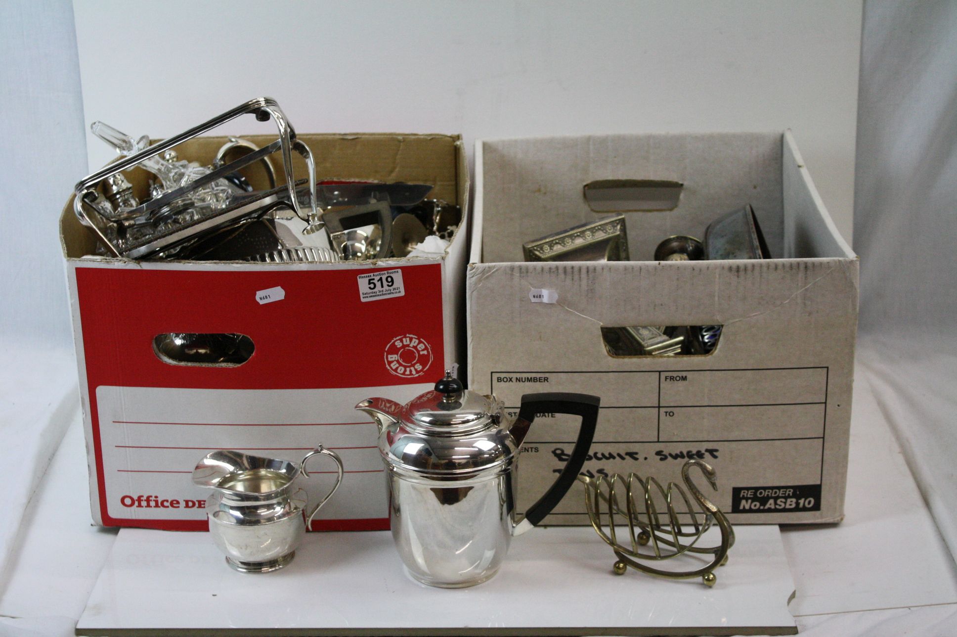 A large quantity of silver plated items contained within two boxes to include candlesticks, toast