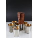 A set of six stainless steel leather cased stirrup cups marked Cross.