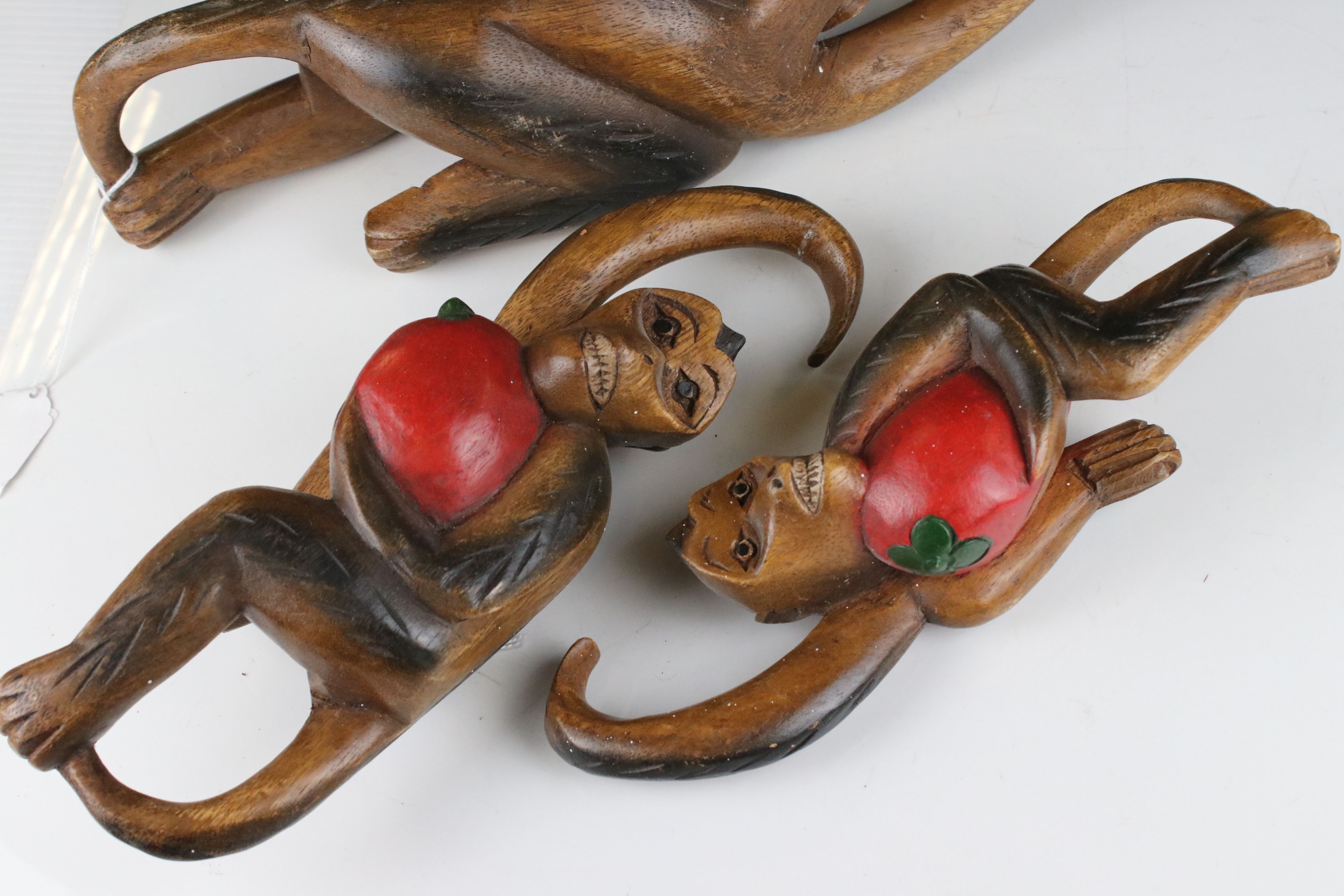 Three Carved Wooden Hanging Monkeys holding Fruit, largest 36cms high - Image 5 of 6