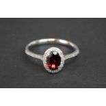 18ct white gold garnet and diamond cluster ring of 1.1cts