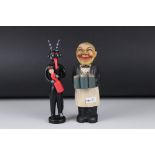 A black Forest style Clothes brush figure waiter holding three pints together with a carved wooden