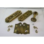 A collection of brass door finger plates together with a brass toilet roll holder.