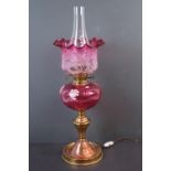 A brass lamp with graduated cranberry shade.