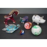 A group of glass animals to include two pigs a turtle a horse a duck and two paperweights.