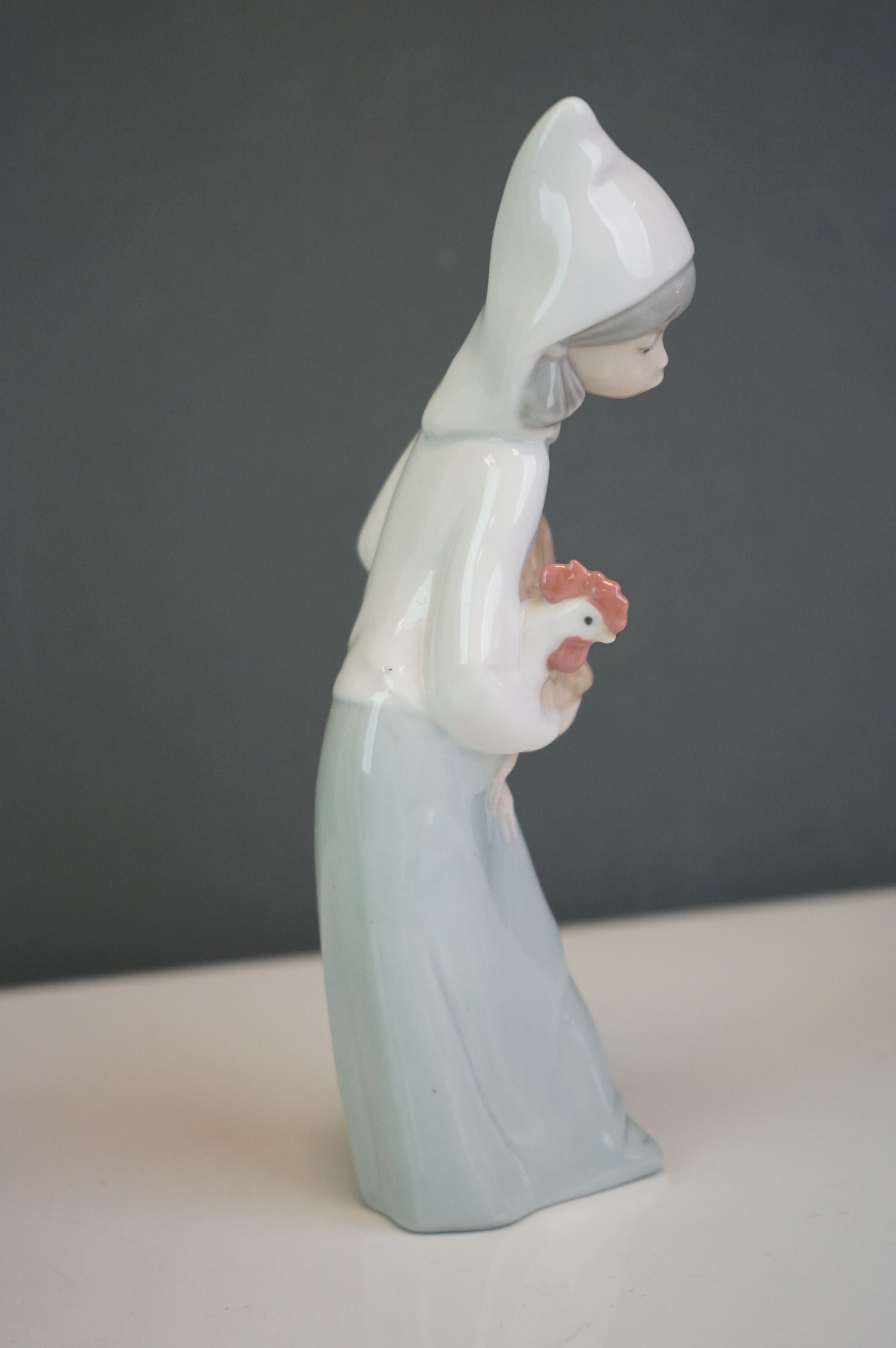 A Lladro bust of a woman in a cowl, together with a girl holding a hen (2) - Image 7 of 9