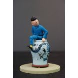 A small resin figure of Tin Tin in a vase.