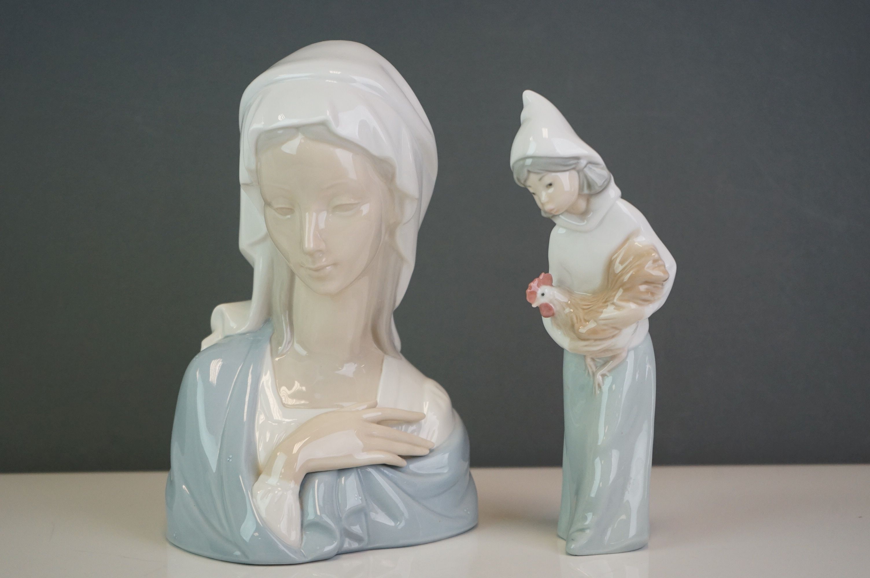 A Lladro bust of a woman in a cowl, together with a girl holding a hen (2)