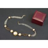 A vintage simulated pearl necklace on white metal chain.
