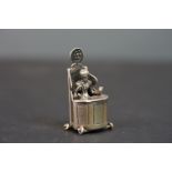 A small Silver plated seated figure of a judge
