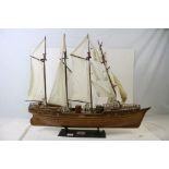 A kit built wooden model sailing ship of the Cutty Sark on stand.