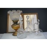A box of mixed collectables to include a brass oil lamp, three glass decanters and two framed
