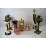 A collection of brass and ceramic oil lamps together with a large resin Art Deco style figure.