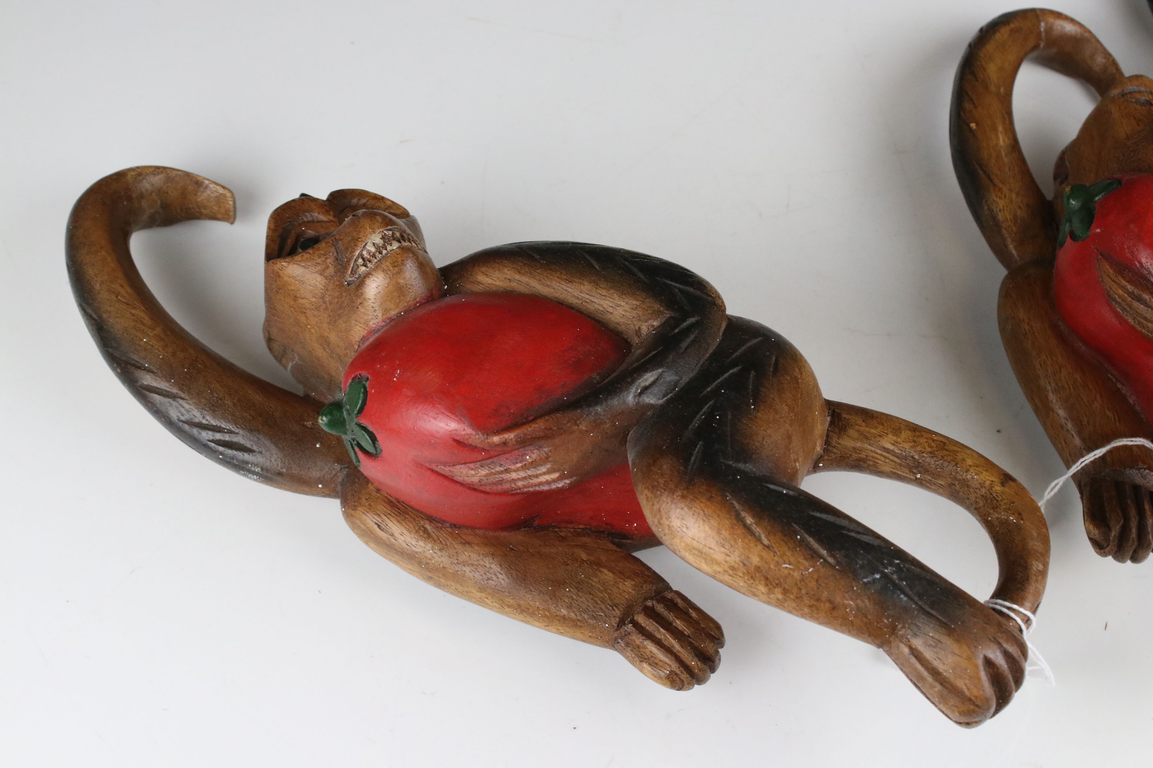 Three Carved Wooden Hanging Monkeys holding Fruit, largest 36cms high - Image 2 of 6