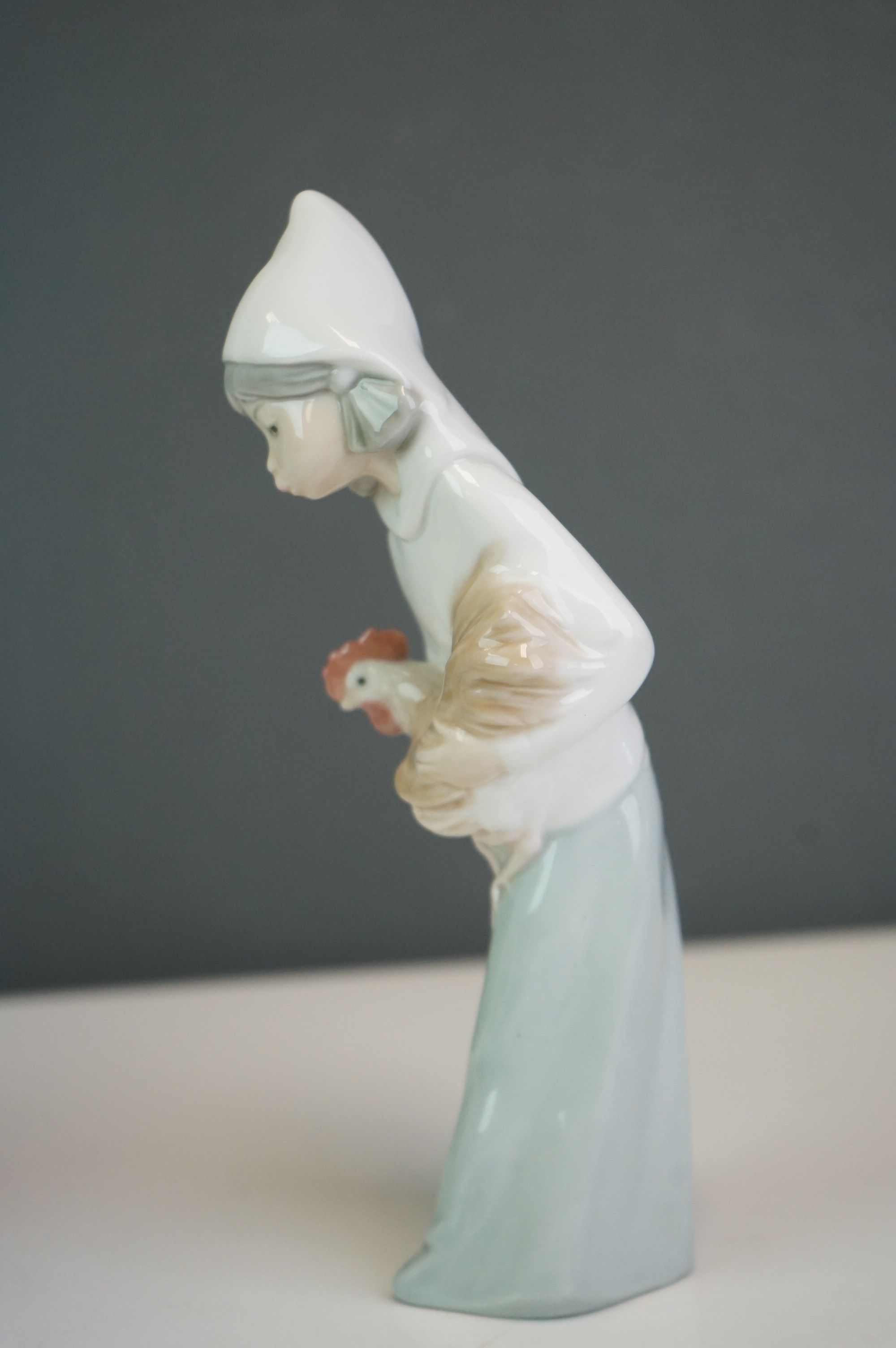 A Lladro bust of a woman in a cowl, together with a girl holding a hen (2) - Image 9 of 9