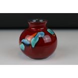 A late 20th century red ground Poole Pottery vase of squat form, 10 cm tall.
