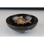 An Oriental pottery footed bowl with fish decoration to interior, 15 cm diameter x 6 cm tall.