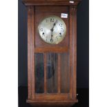 A wooden cased chiming wall clock.