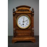 A wooden cased mantle clock with blue enamel dial, single train movement