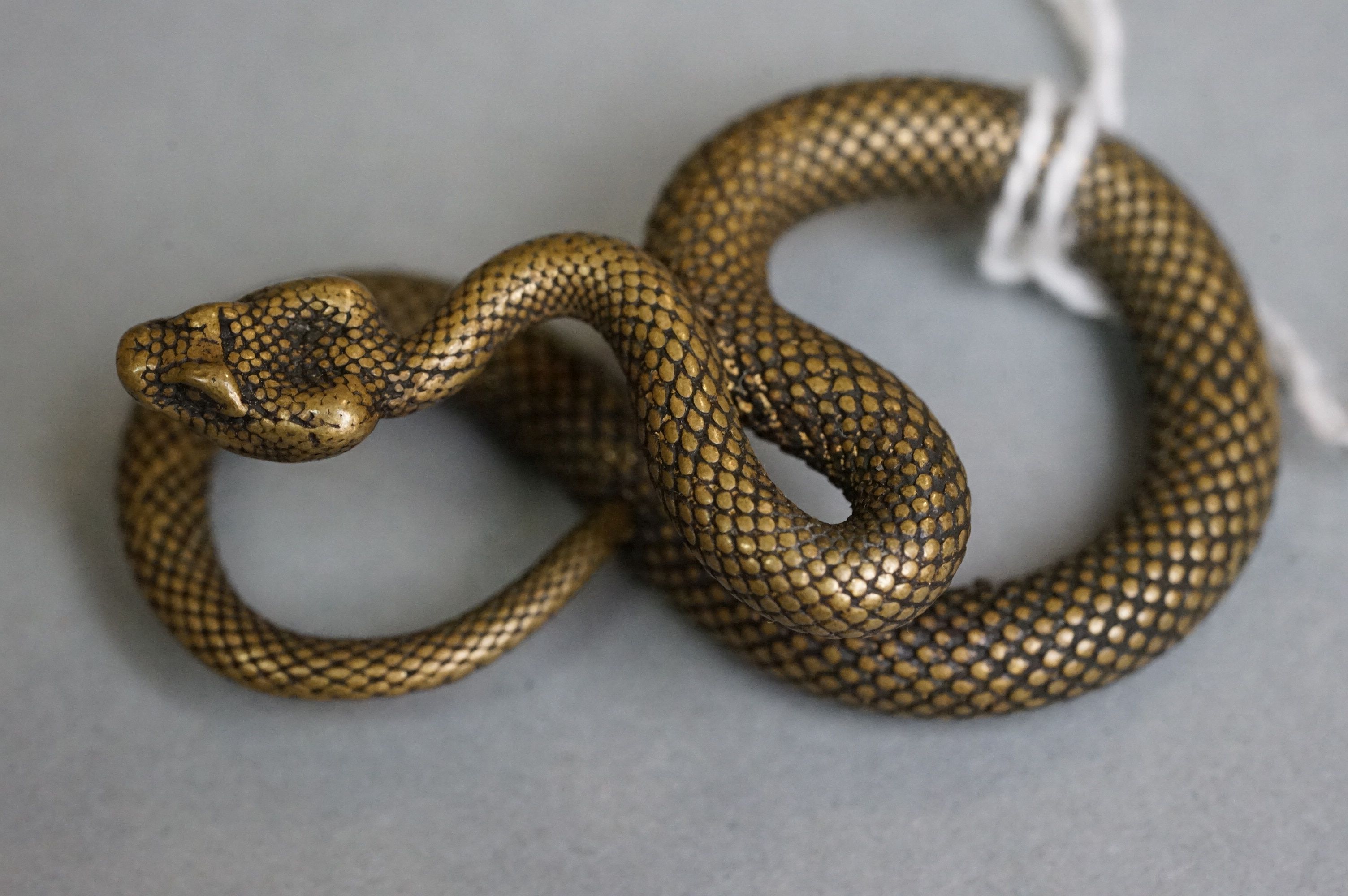 A small metal figure of a viper snake.