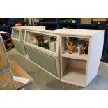 A white painted mid 20th century bakery shop part glazed counter consisting of four sections.