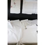 A large collection of vintage white linen table cloths
