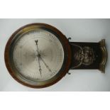 An early 20th century oak cased barometer with lion mask decoration.