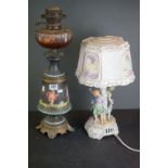 A antique ceramic oil lamp with cherub decoration together with a continental ceramic table lamp.