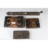 Three antique door locks and a brass door bolt.