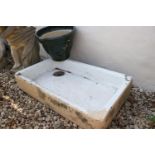 A white Belfast sink together with a green painted planter.