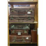 A collection of six vintage brown leather suitcases.