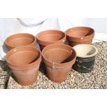 A group of five large terracotta planter pots together with two other pots.