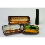 A collection of four cheroot holders to include Amber examples with gold and silver mounts.