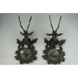 A pair of metal mirrored wall sconces with stag decoration.