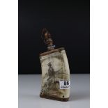 A vintage horn powder flask with Scrimshaw style decoration hunter with dog.