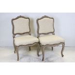 Pair of French Side Chairs with distressed painted carved frames, upholstered in cream fabric, 92cms
