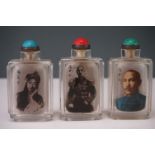 A collection of three Chinese glass snuff bottles with internal transfer images and script.
